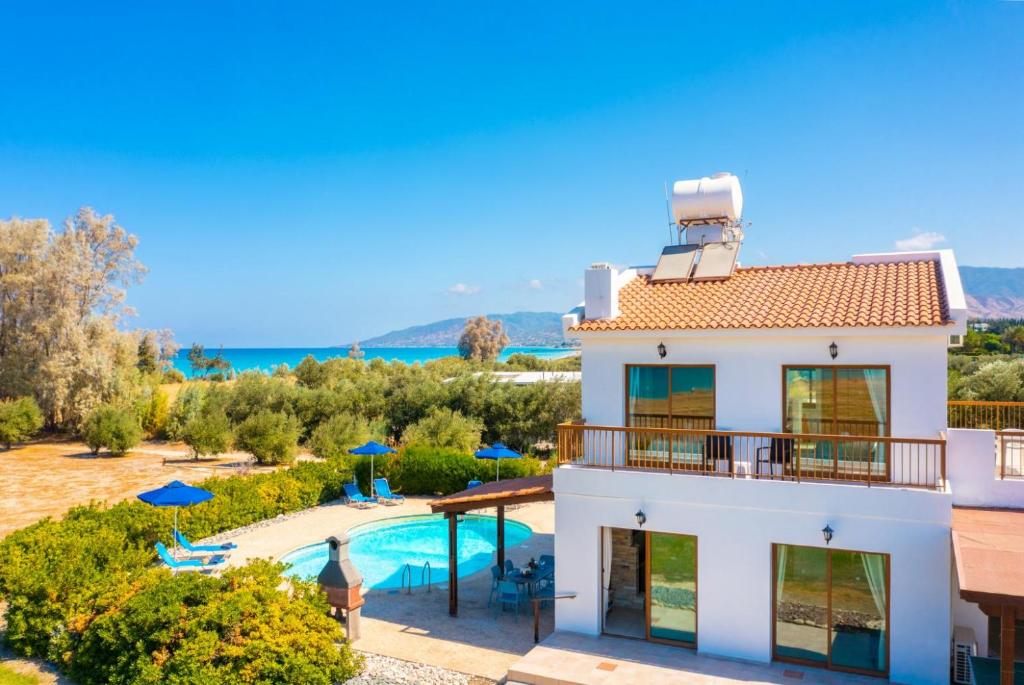 a villa with a swimming pool and a house at Blue Bay Villa Nicole in Mavroli