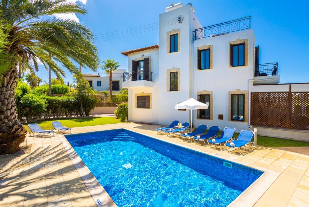 a villa with a swimming pool in front of a house at Villa Anna in Lachi
