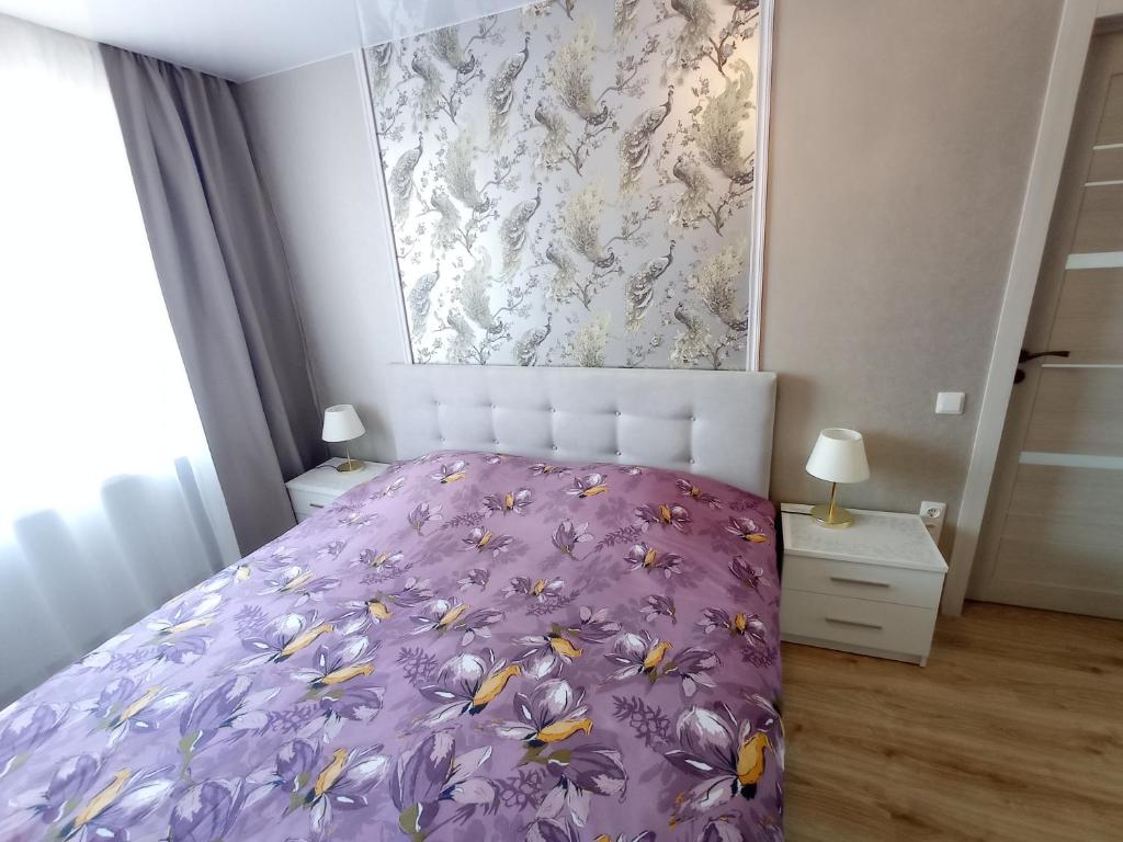 a bedroom with a bed with a purple comforter at New Energia apartment in center city in Narva