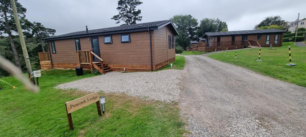 a couple of buildings on a dirt road at Peacock Lodge - Sleeps 4 - 2 Bedrooms in East Looe