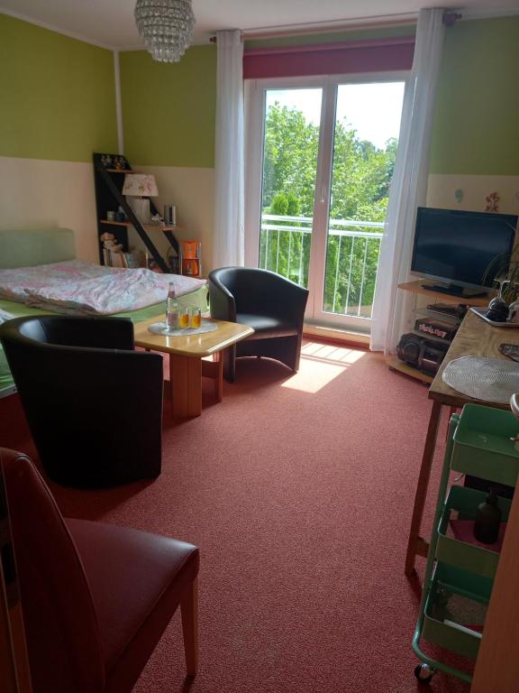 een slaapkamer met een bed en een tafel en stoelen bij Hübsches Zimmer nahe BER in Berlijn