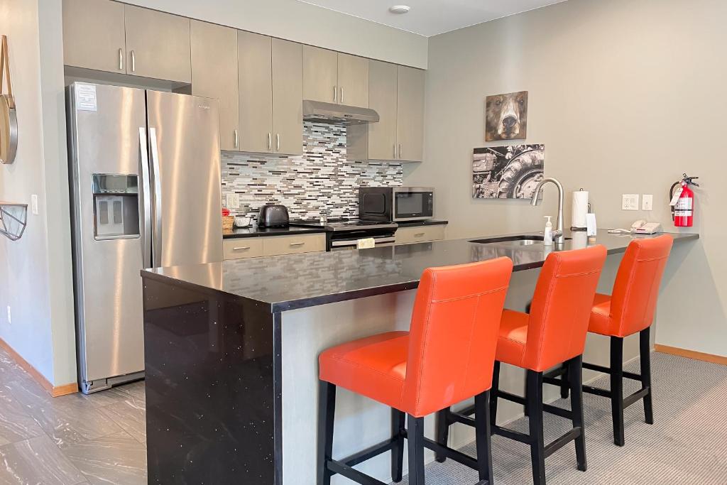 a kitchen with orange chairs at a kitchen counter at Tumwater Vista Retreat, Unit 903 in Leavenworth