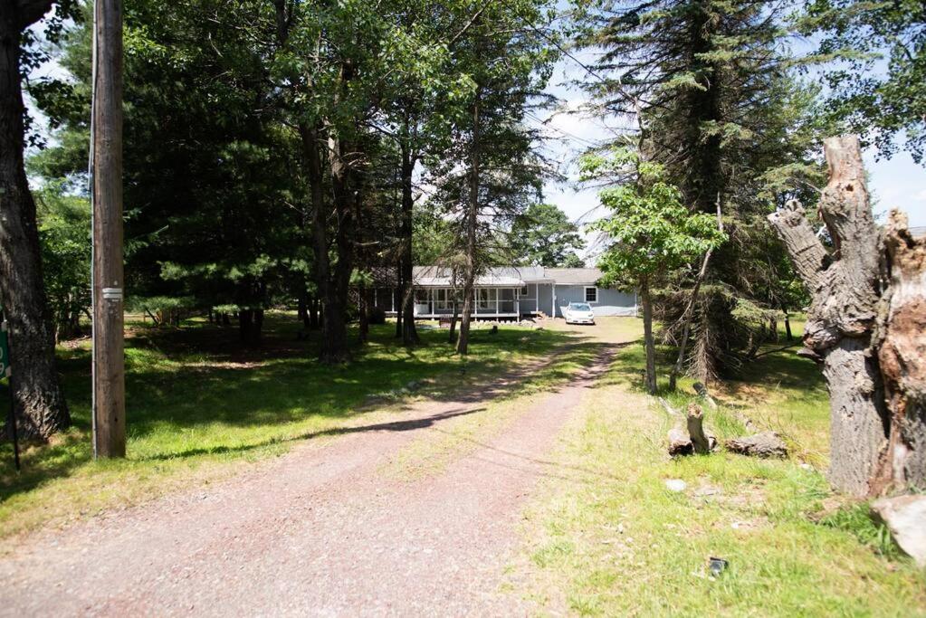 a dirt road in front of a house with trees at The Hob Knob! Luxury Pocono Ranch near waterparks! in Albrightsville