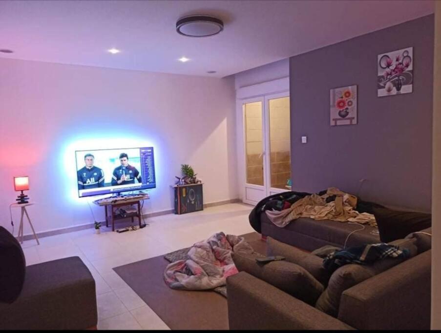 een woonkamer met een bank en een flatscreen-tv bij appartement propre in El Bayadh