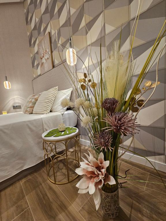 ein Schlafzimmer mit einem Bett und einem Tisch mit Blumen in der Unterkunft Lounge garden sea relax in Valencia