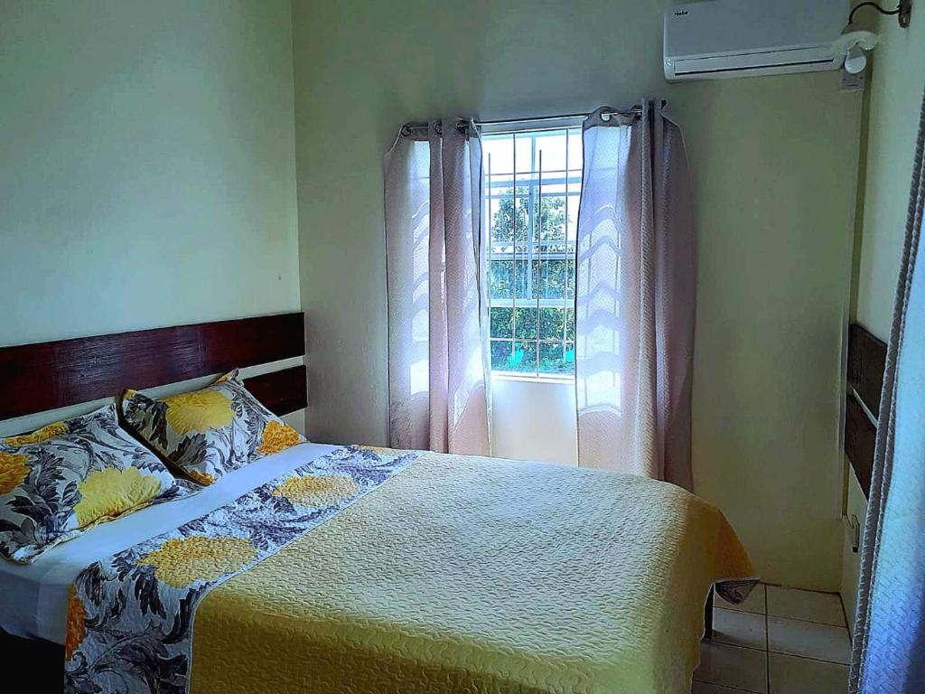 a bedroom with a bed and a window at Juju's Cottage with magnificent views in Laborie