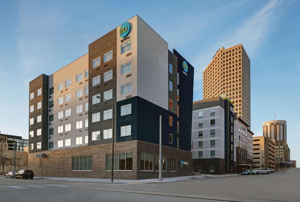 密尔沃基Tru By Hilton Milwaukee Downtown, WI的一座高楼，楼顶有标志