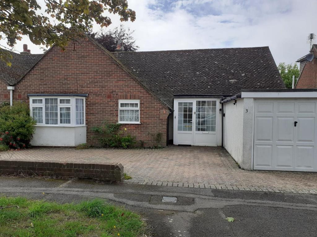 a brick house with white doors and a driveway at silver way in Highcliffe