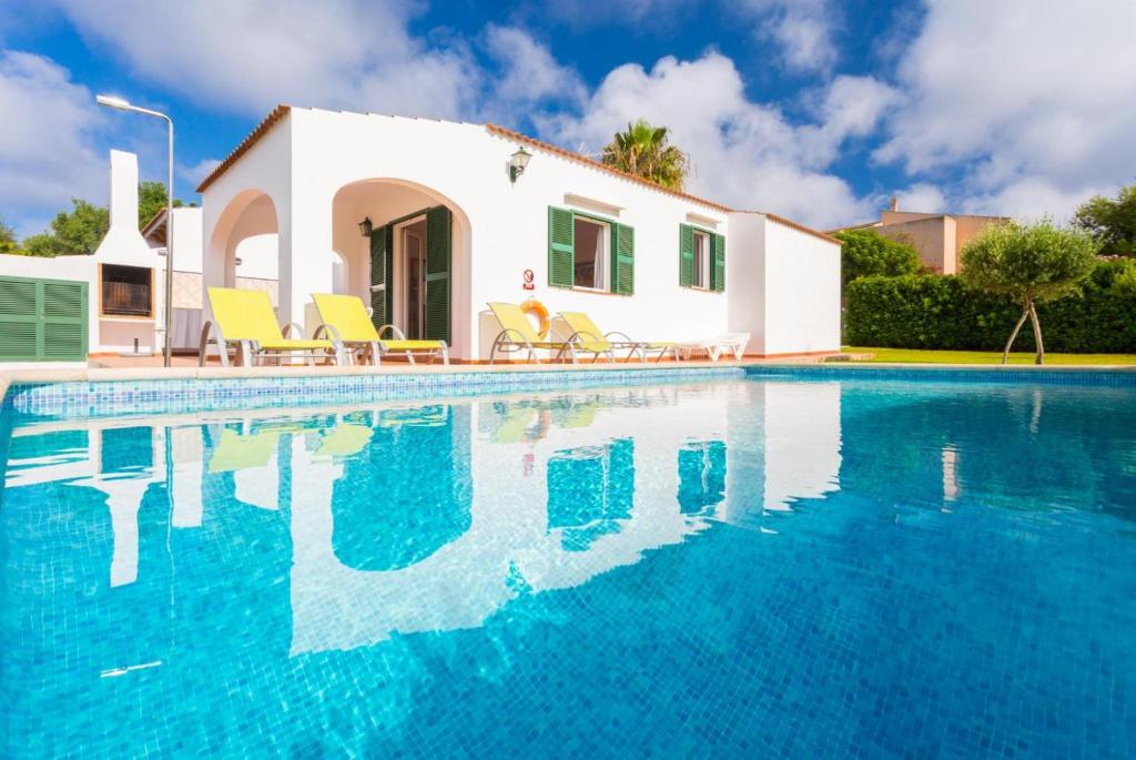 a villa with a swimming pool in front of a house at Villa Gelabert Ametller in Cala en Bosc