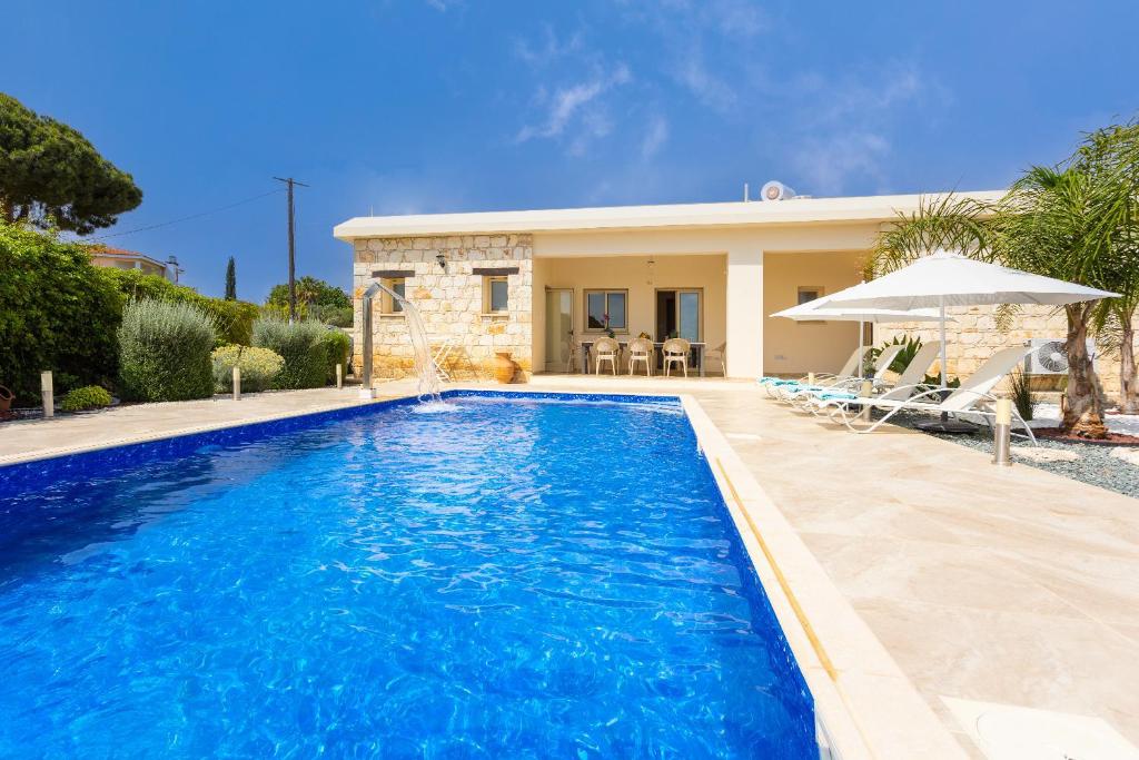 a swimming pool in front of a house at Villa Elite in Droushia