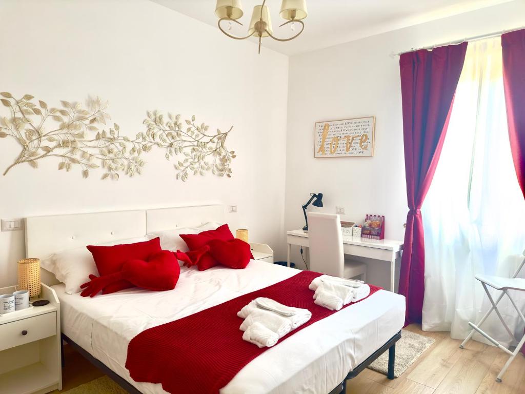 una camera da letto con un grande letto con cuscini rossi di Gemelli-San Pietro-Trastevere-casa con posto auto a Roma