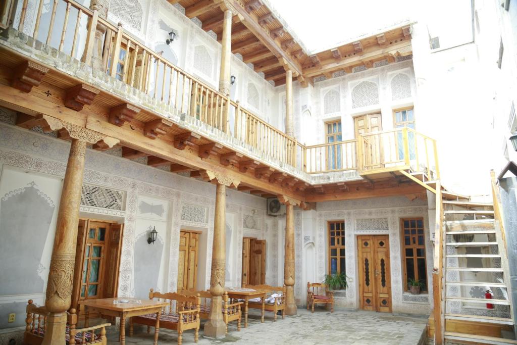 Habitación grande con escalera de madera en un edificio en Komil Bukhara Boutique Hotel, en Bukhara