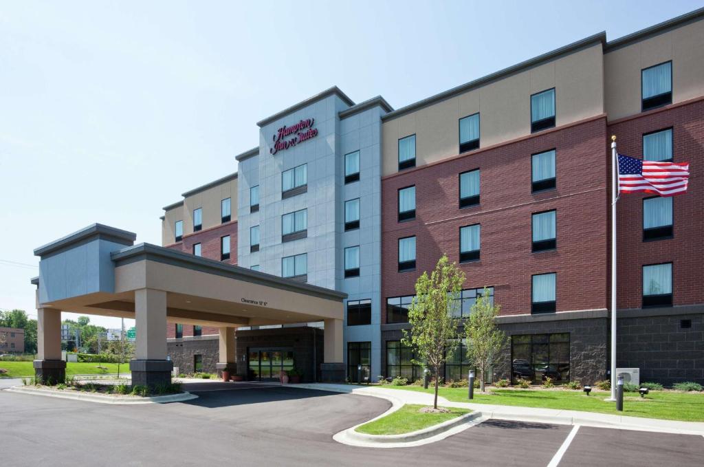 ミネトンカにあるHampton Inn & Suites Minneapolis West/ Minnetonkaのアメリカ旗を掲げたホテルの外観