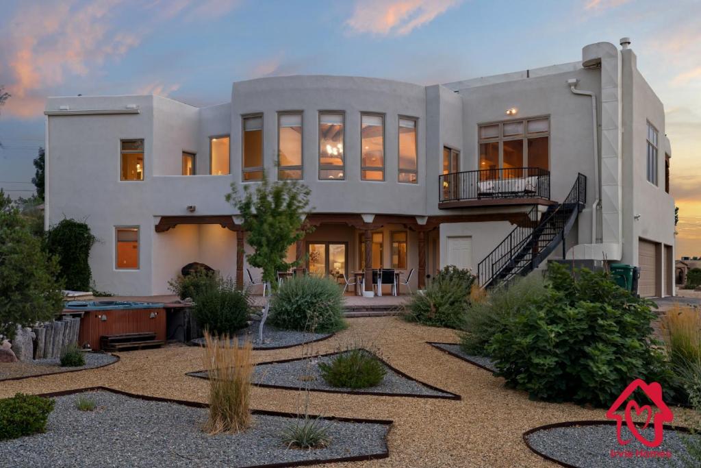 uma grande casa branca com um jardim em frente em Elena's Sandia Sanctuary - An Irvie Home em Albuquerque