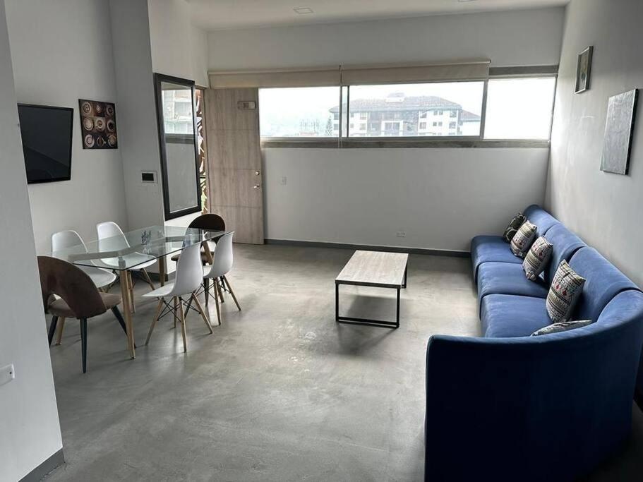 - un salon avec un canapé bleu et une table dans l'établissement Asombroso Apto 302 Para Grupos en El Poblado, à Medellín