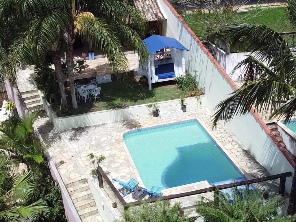een uitzicht over een zwembad met palmbomen bij Pousada Tehau Guest House in Búzios