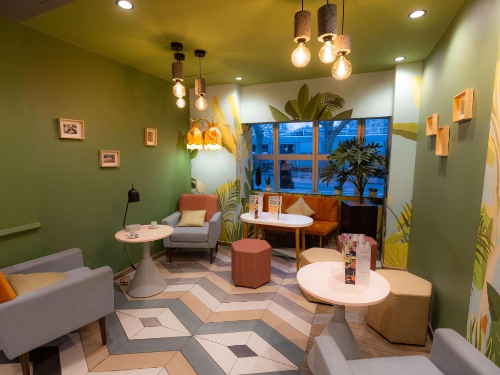 ein Restaurant mit Tischen und Stühlen in einem Zimmer in der Unterkunft ibis Besançon Centre la City in Besançon
