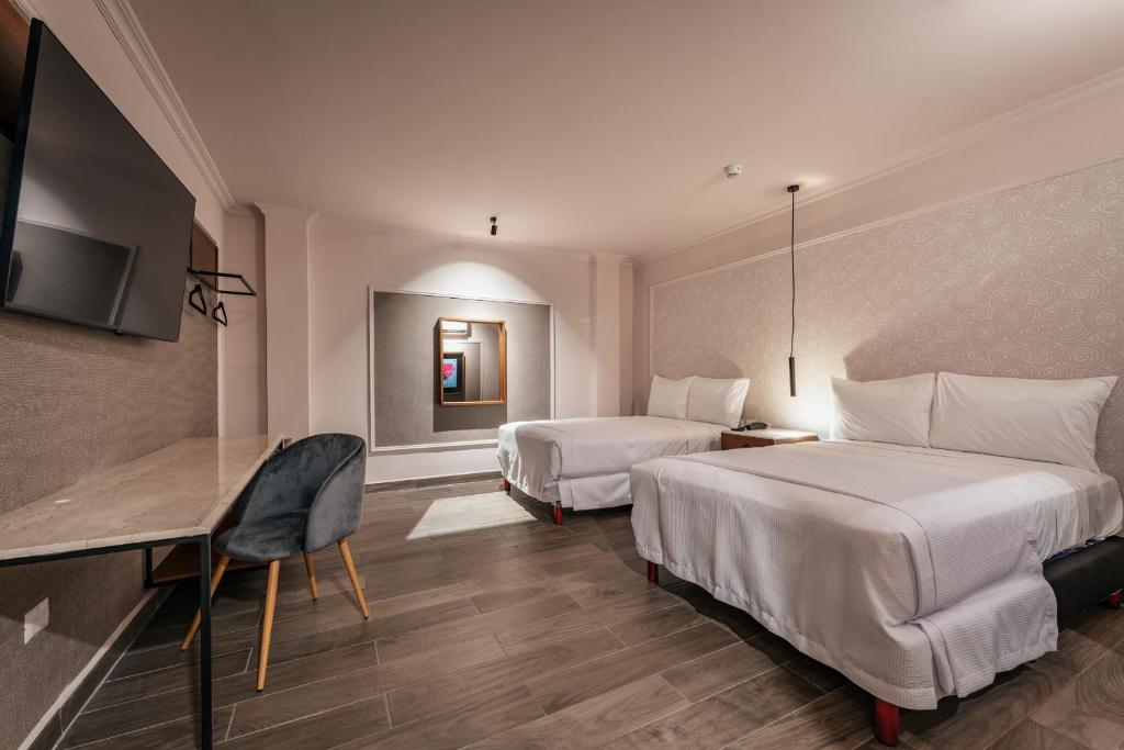 梅里達的住宿－Hotel MID Project，酒店客房配有两张床和一张书桌