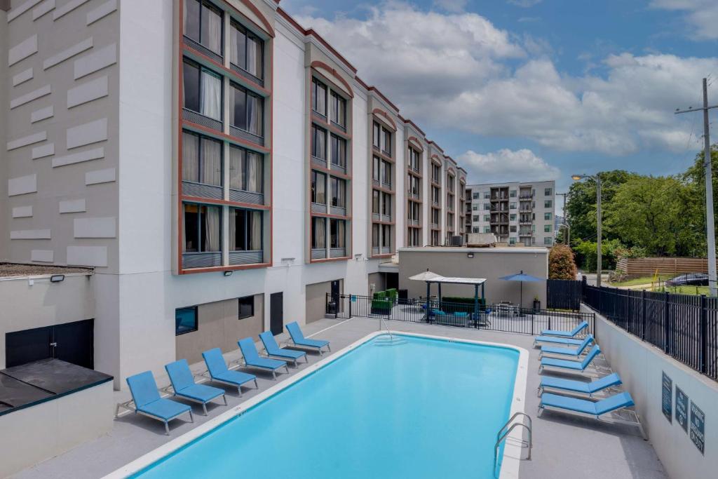 a swimming pool with chairs and a building at Best Western PLUS Downtown/Music Row in Nashville