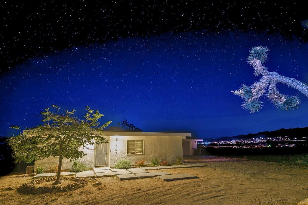 een huis met een boom voor een nachtelijke hemel bij Perfect Getaway withAmazing Views at Joshua Tree home in Yucca Valley