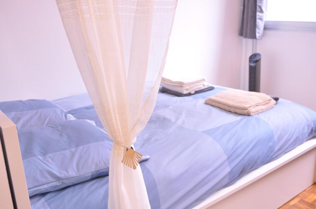 a bedroom with a bed with a curtain at Javelot1 Cosy studio paris13 10min to Louvre in Paris