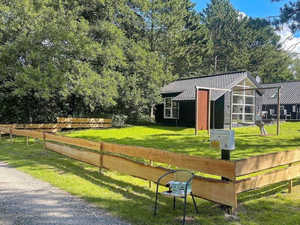 una valla de madera frente a una casa en 8 person holiday home in Ebeltoft en Øksenmølle