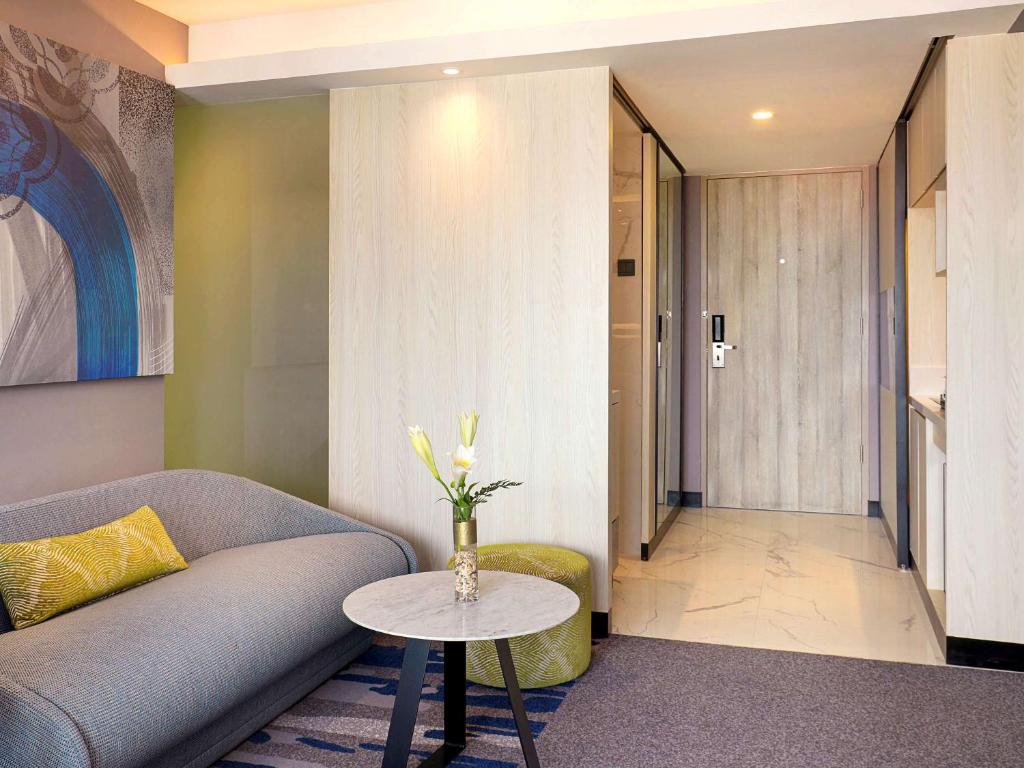 a living room with a couch and a table at Novotel Suites Yogyakarta Malioboro in Yogyakarta