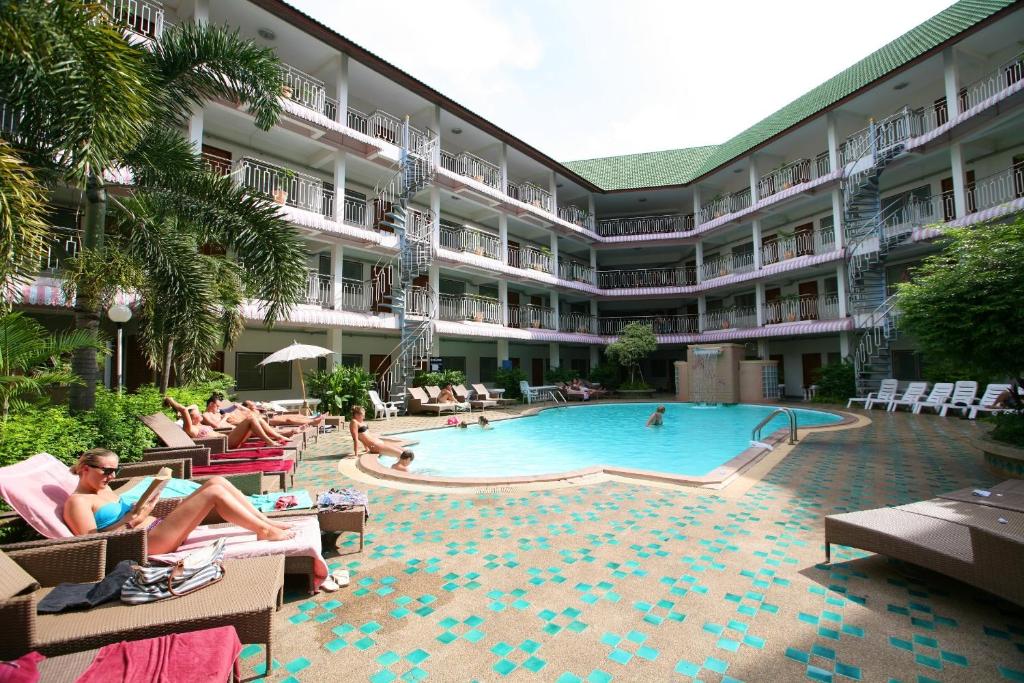 a pool at a hotel with people sitting around it at Top North Hotel in Chiang Mai