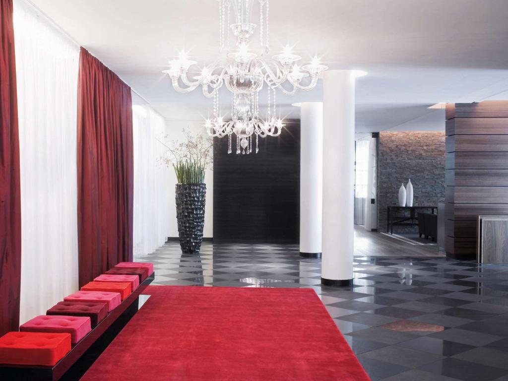 a lobby with a red carpet and a chandelier at Mövenpick Hotel Stuttgart Airport in Stuttgart