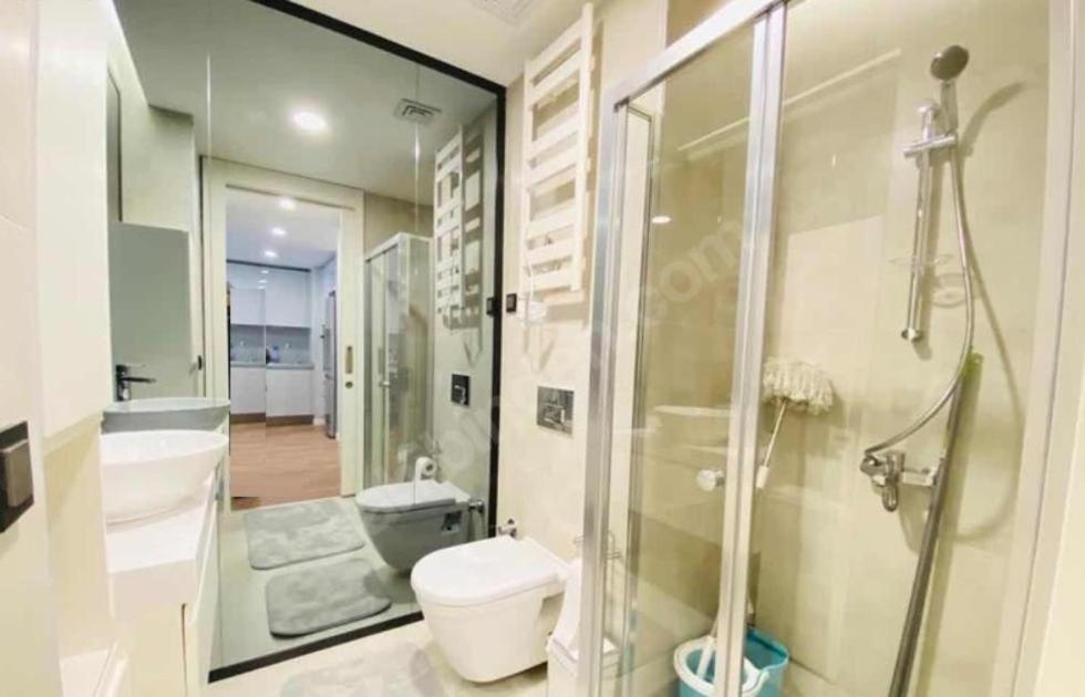 uma casa de banho com um chuveiro, um WC e um lavatório. em TOYA Next Residence em Istambul