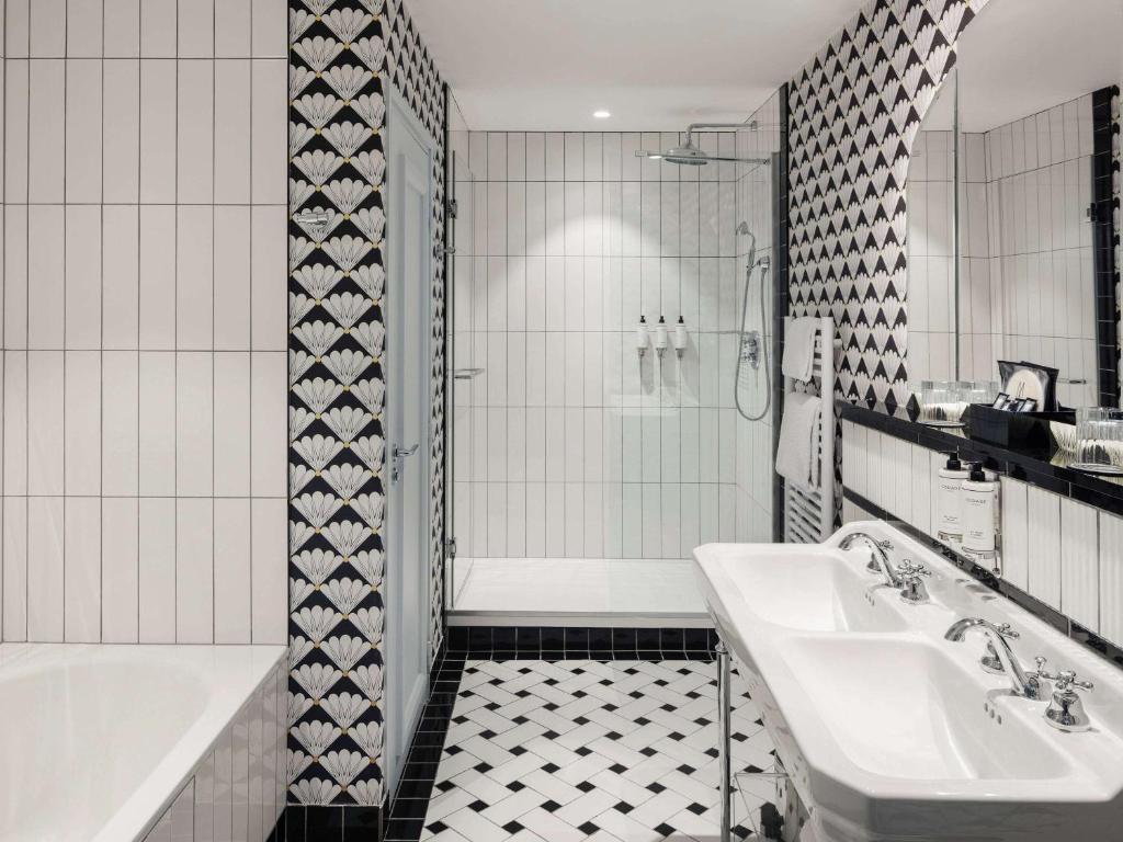 a white bathroom with a tub and a sink at The 1932 Hotel & Spa Cap d'Antibes - MGallery Collection in Juan-les-Pins