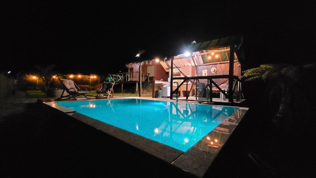 ein Schwimmbad vor einem Haus in der Nacht in der Unterkunft Chalé Colina in Venda Nova do Imigrante