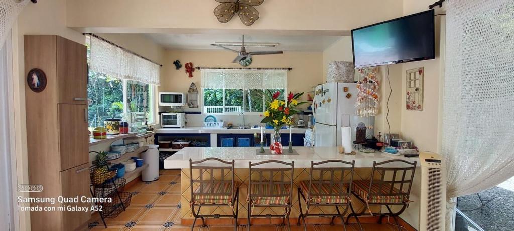 a kitchen with a table and chairs and a refrigerator at Yethan house in Uvita