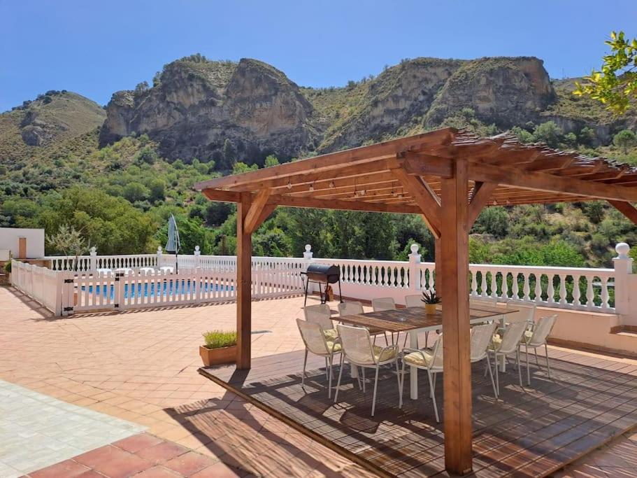 a wooden pavilion with a table and chairs on a patio at Edelweiss, Casa Rural in Granada