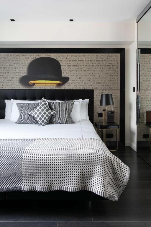 a bedroom with a large bed with a black and white bedspread at Holmes Hotel London in London