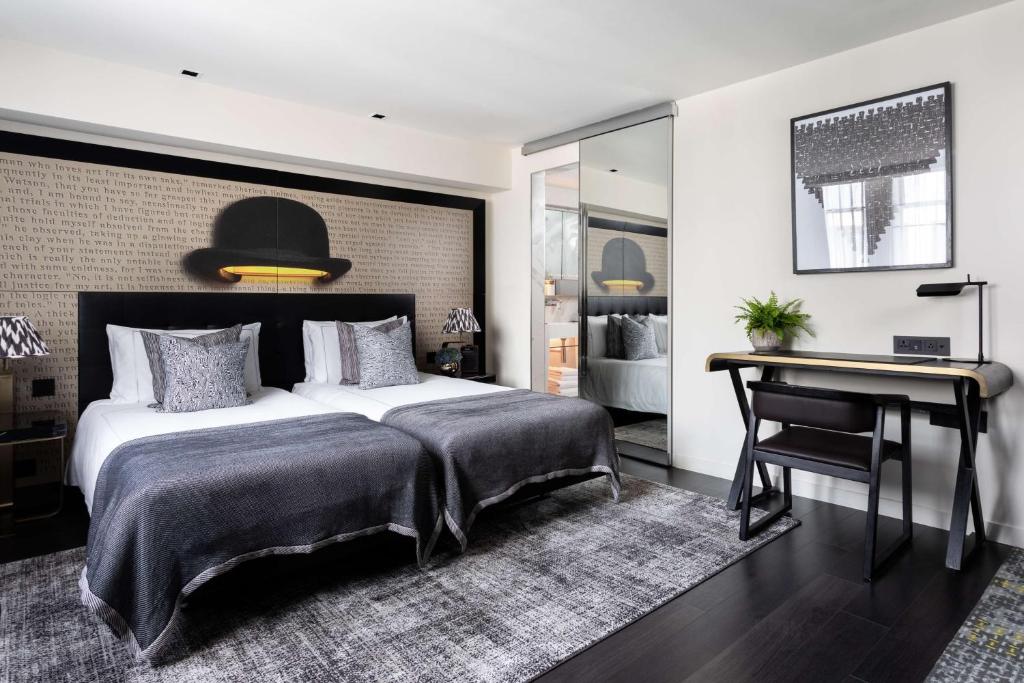a bedroom with a large bed and a desk at Holmes Hotel London in London
