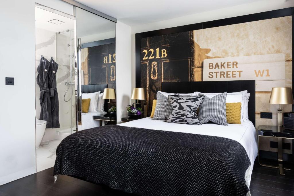 a bedroom with a black and white bed and a bathroom at Holmes Hotel London in London