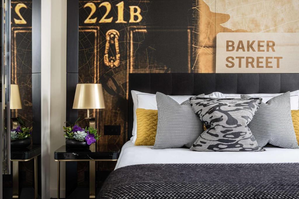a bedroom with a bed with black and yellow pillows at Holmes Hotel London in London