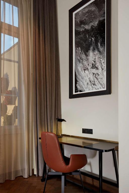 a desk with a red chair next to a window at Holmes Hotel London in London