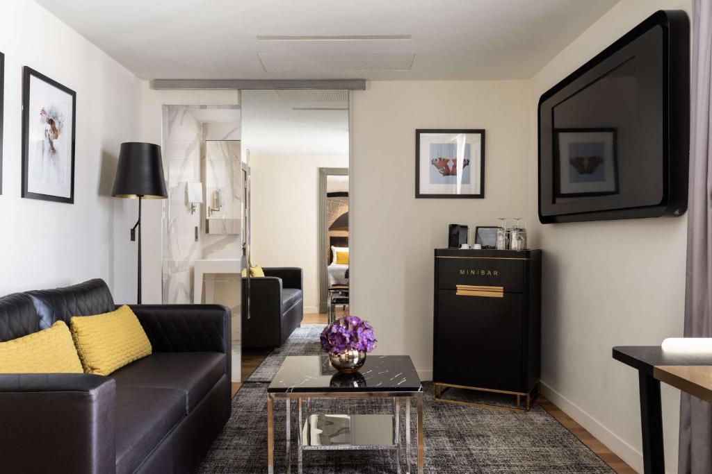 a living room with a couch and a tv at Holmes Hotel London in London