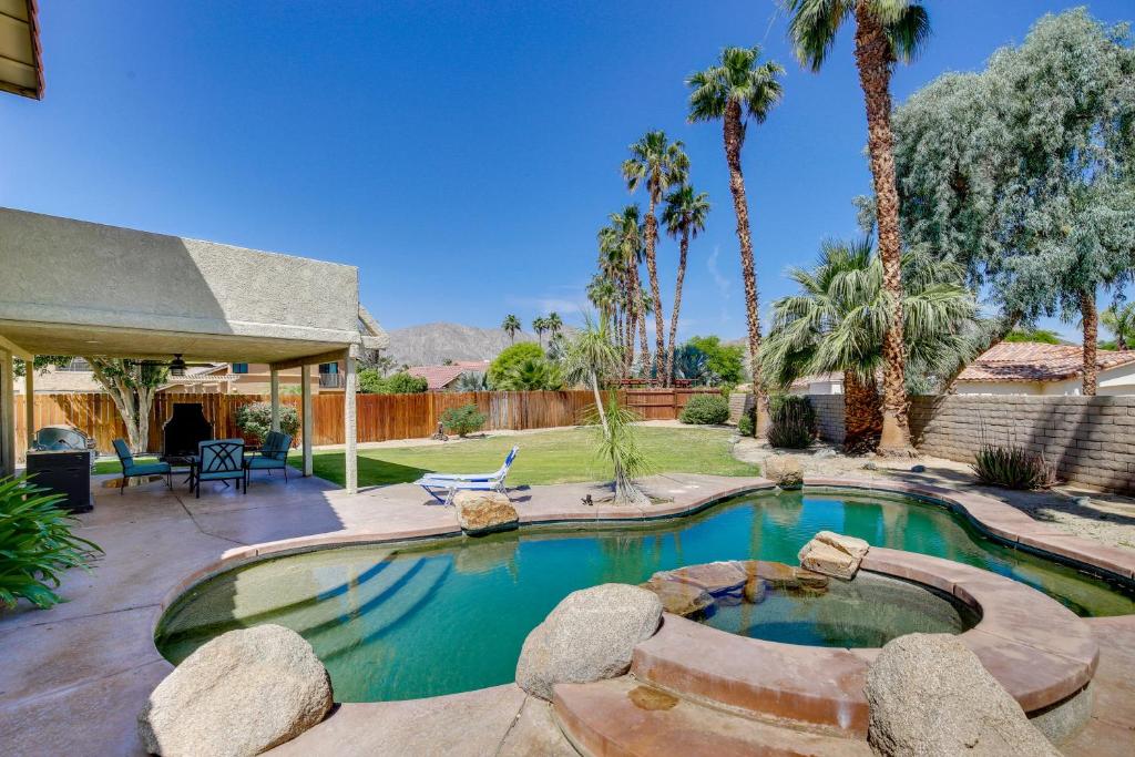einen Pool in einem Garten mit Palmen in der Unterkunft Beautiful La Quinta Oasis with Pool and Spa! in La Quinta