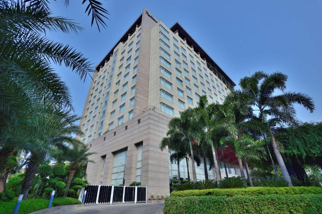 un edificio alto con palme di fronte di Radisson Blu Hotel, Indore a Indore