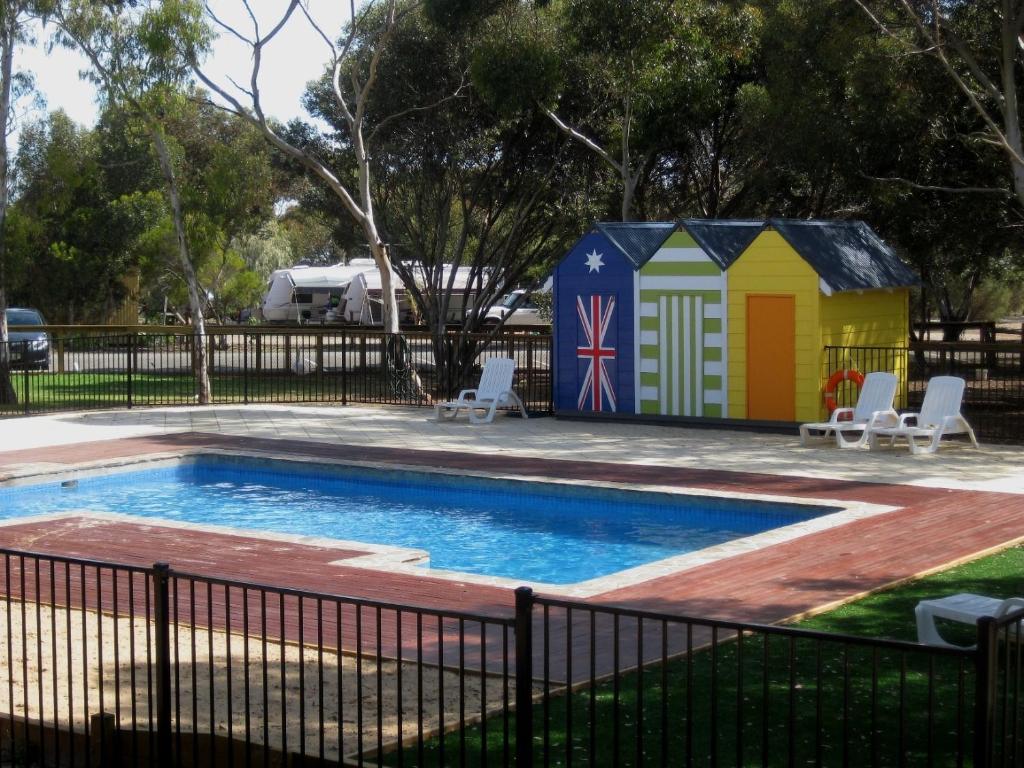 a small pool with a building next to a fence at BIG4 Port Willunga Tourist Park in Aldinga