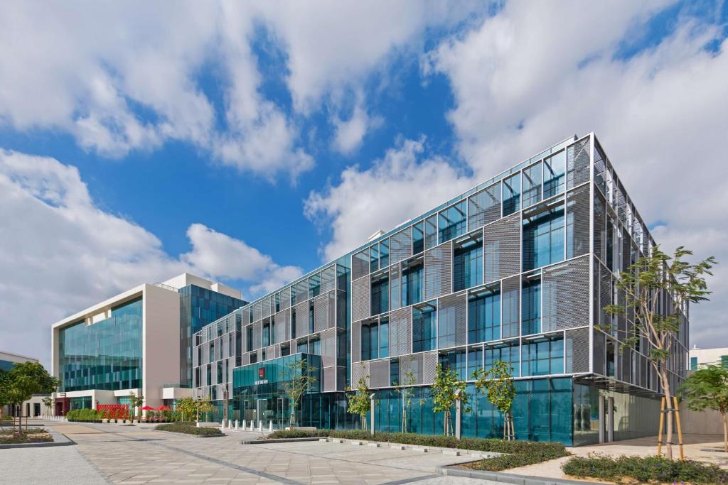 an office building with glass windows and a blue sky at Radisson RED Dubai Silicon Oasis in Dubai