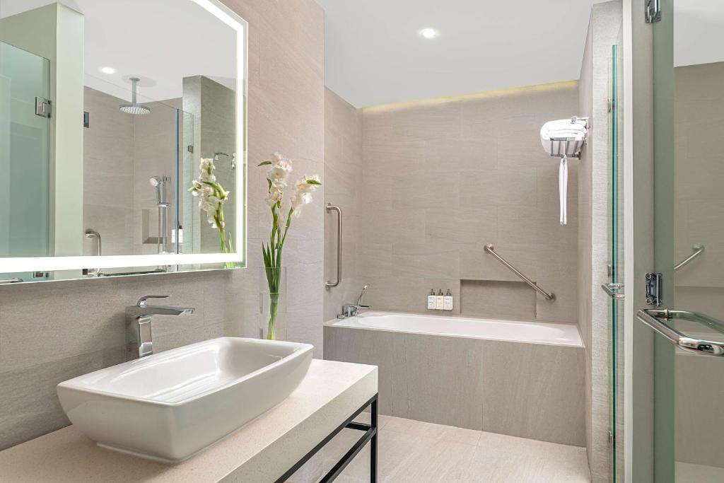 uma casa de banho branca com um lavatório, uma banheira e um tubermott em Park Inn By Radisson Bacolod em Bacolod