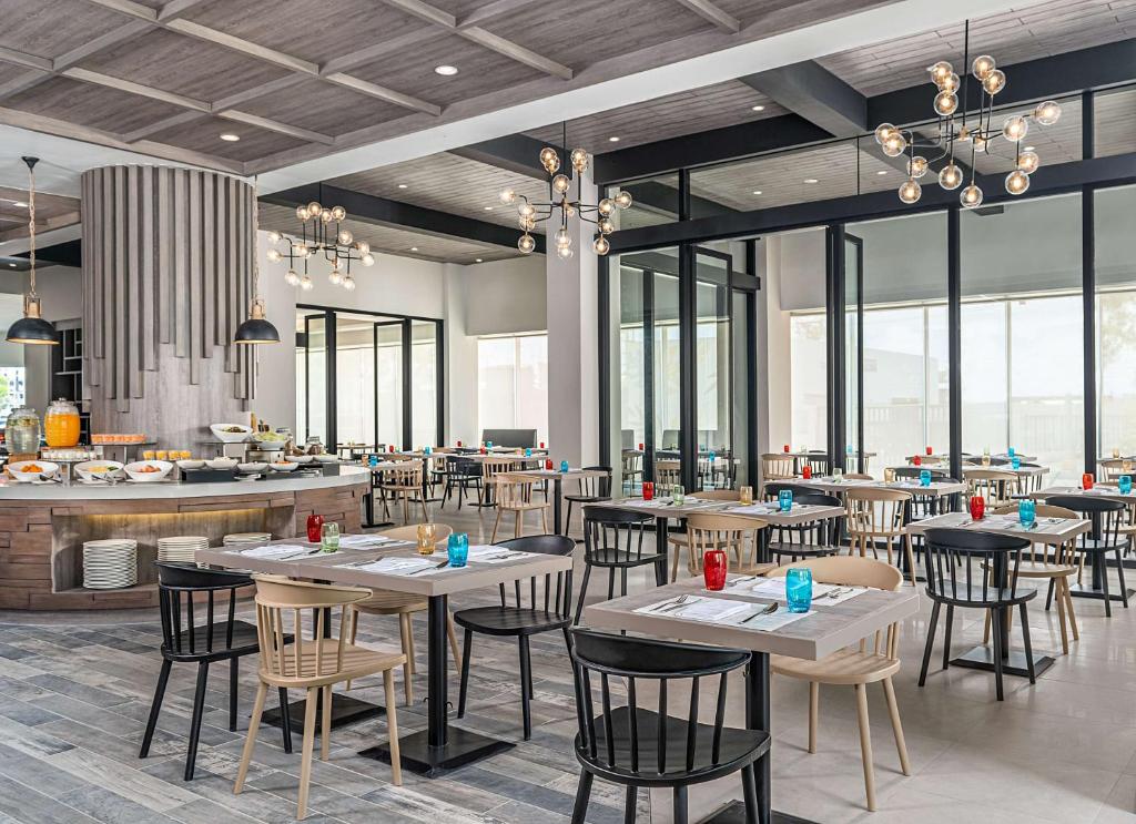 um restaurante com mesas, cadeiras e janelas em Park Inn By Radisson Bacolod em Bacolod