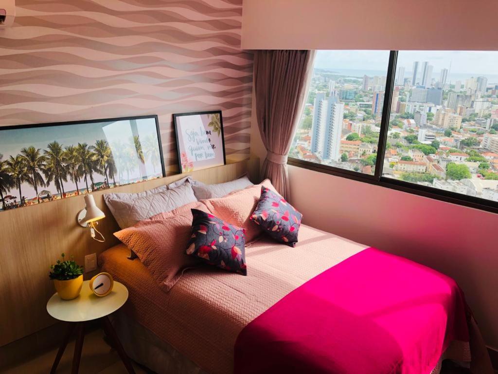 Schlafzimmer mit einem rosa Bett und einem großen Fenster in der Unterkunft FLAT ILHA DO LEITE - DENTRO PÓLO MÉDICO in Recife