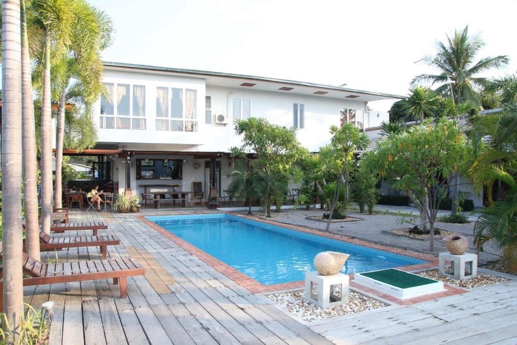 a house with a swimming pool in front of a building at The My Home Resort in Prachuap Khiri Khan