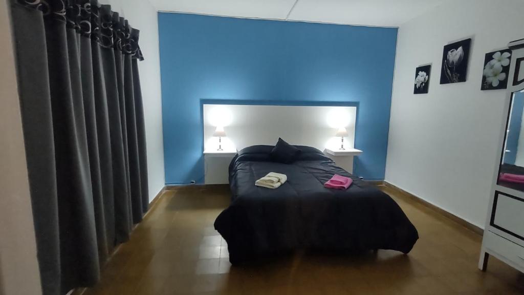 1 dormitorio con 1 cama y luz azul en Departamento Gutiérrez en Maipú