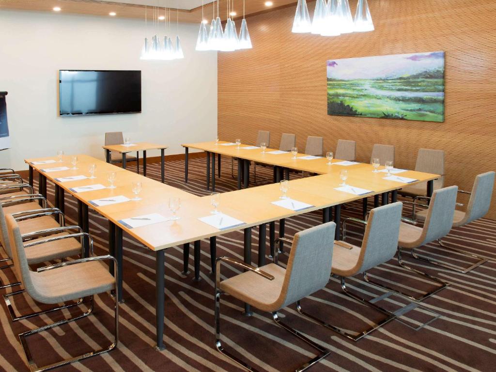 a large conference room with a large table and chairs at Novotel Fujairah in Fujairah